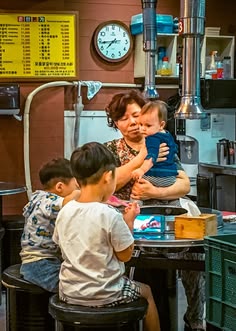 nurturing Ajumma, looking after three children on a tin table at a market